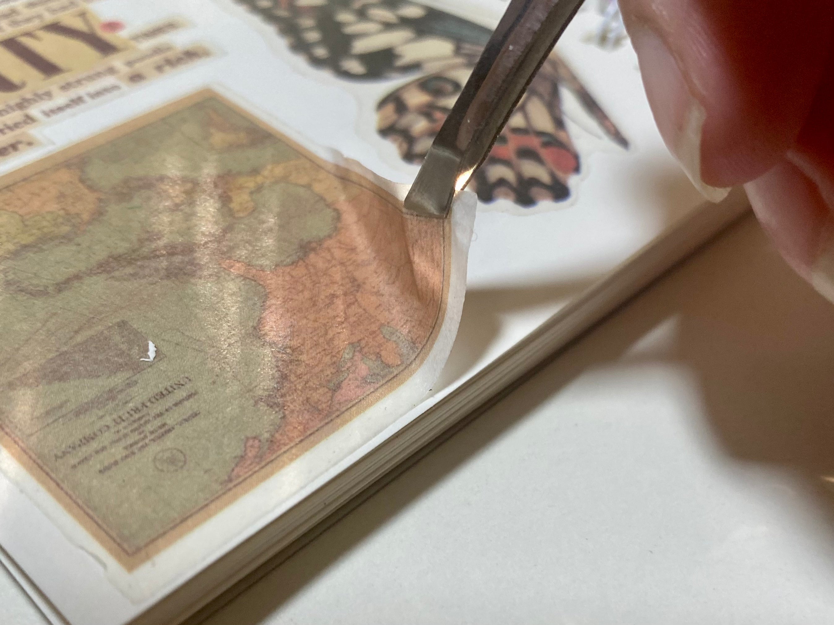 Image shows sticker being peeled from reusable sticker book